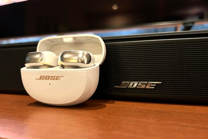 Bose Ultra Open Earbuds in front of a Bose Smart Soundbar.