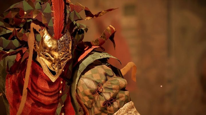 A character in Enotria: The Last Song. It's wearing a burnt masquerade mask, with green and red fabric attached.