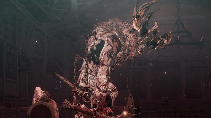 A giant boss towers over a hero in The First Berserker: Khazan.