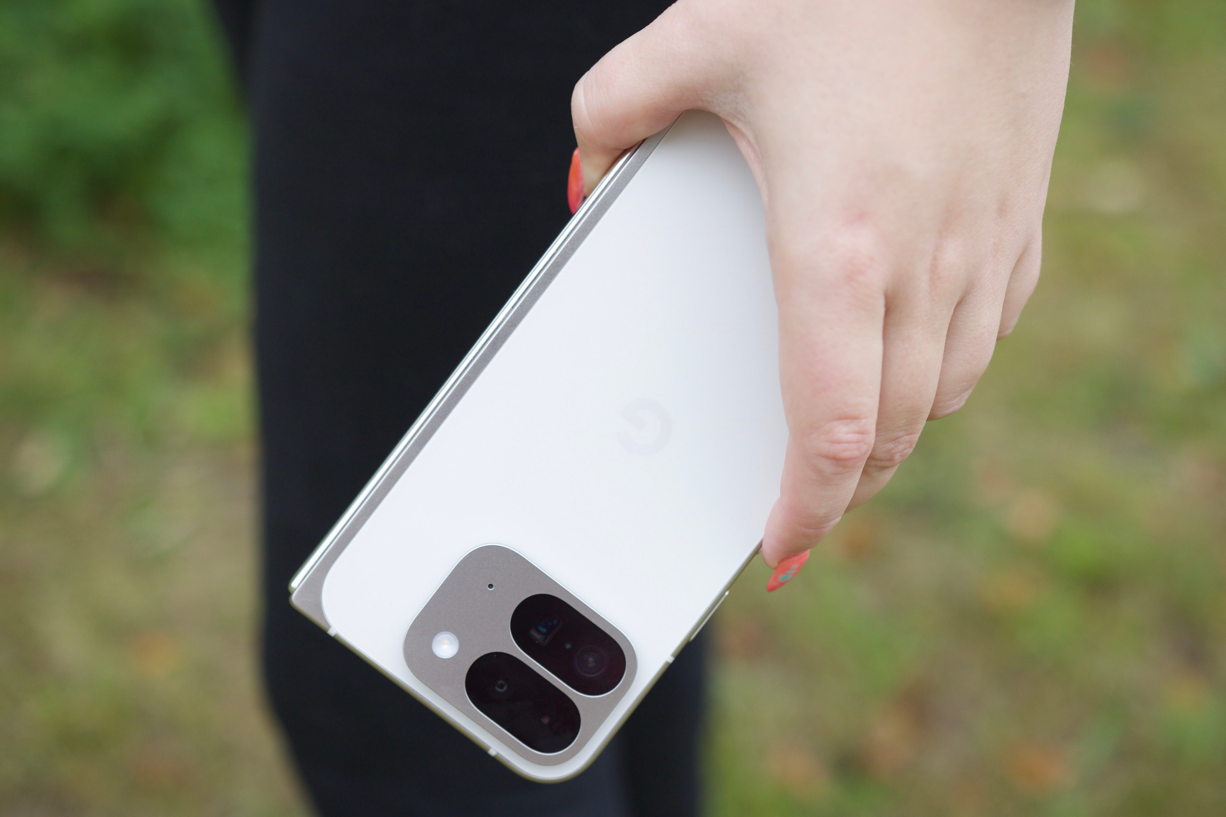 A person holding the Google Pixel 9 Pro Fold, showing the back of the phone.