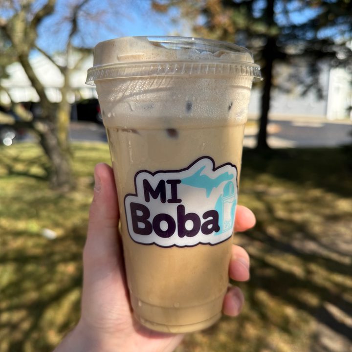 A photo of someone holding a to-go cup of cold brew, taken with the iPhone 16 Pro.