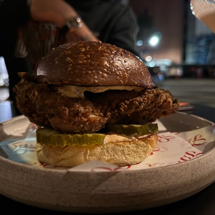 A photo of a fried chicken sandwich outside at night, taken with the iPhone 16 Pro.