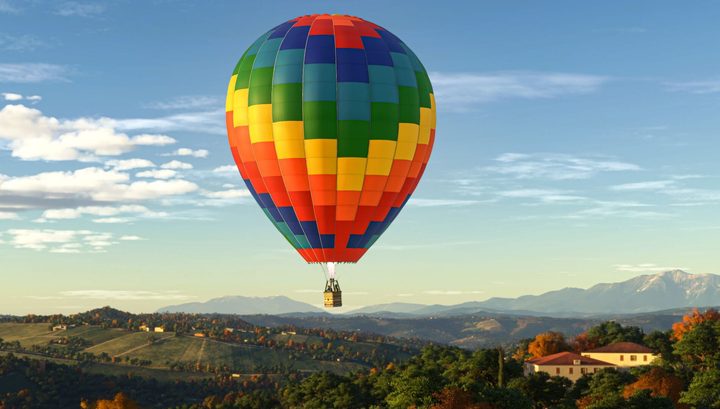 A rainbow colored hot air balloon in the sky.