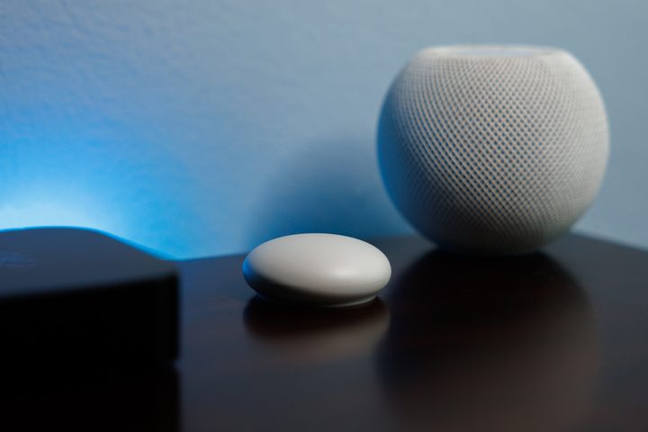 The second-generation Nest temperature sensor seen between an Apple HomePod Mini and Apple TV 4K.