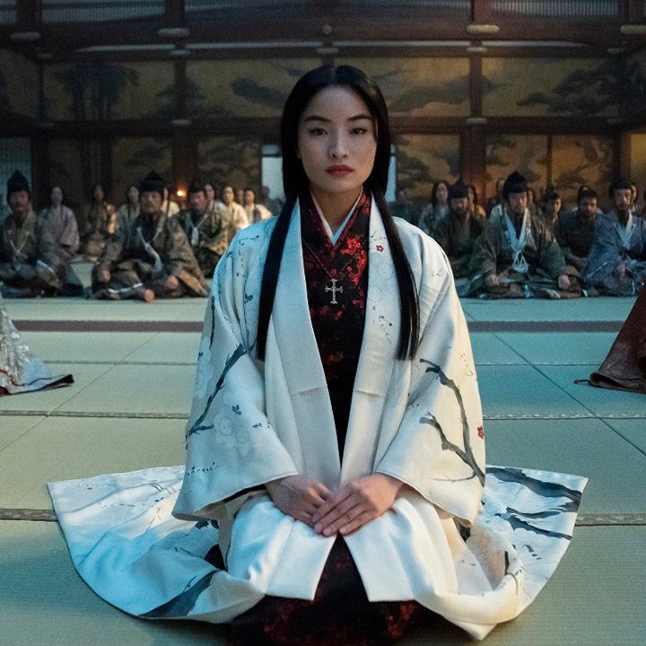 A young woman kneels down on the floor.