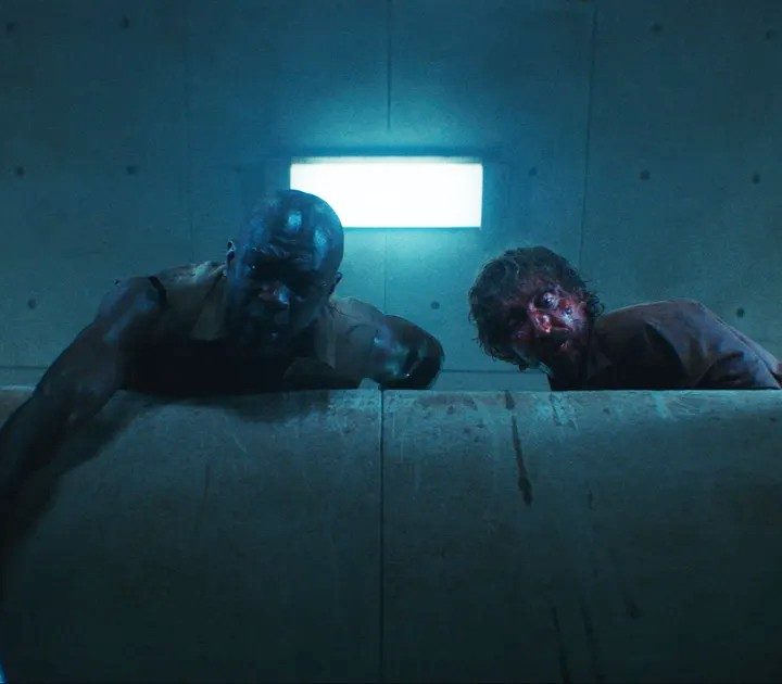 Two men look down in "The Platform."