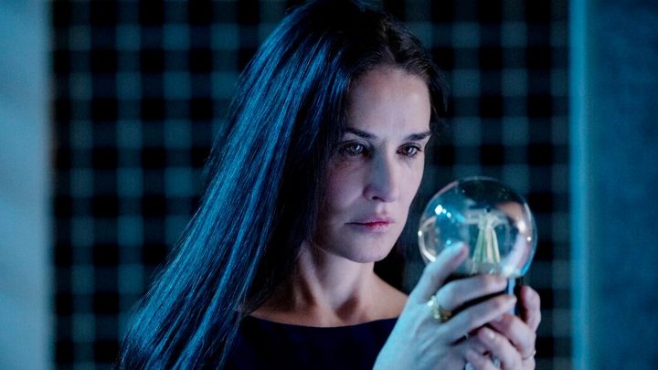 Demi Moore looking at a snow globe in "The Substance."