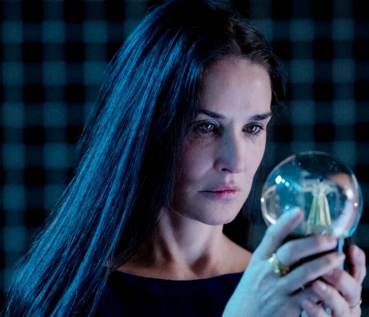 Demi Moore looking at a snow globe in "The Substance."