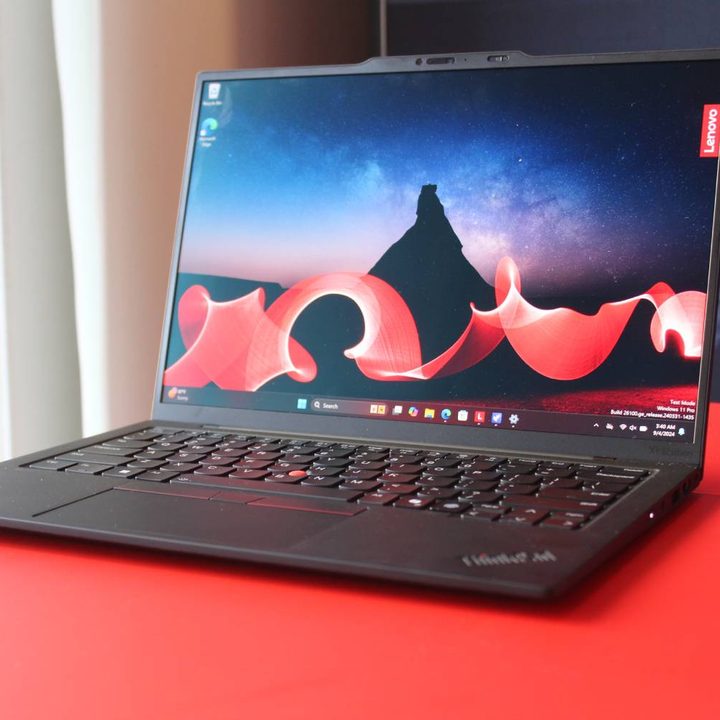 The ThinkPad X1 Carbon Gen 13 on a red table.