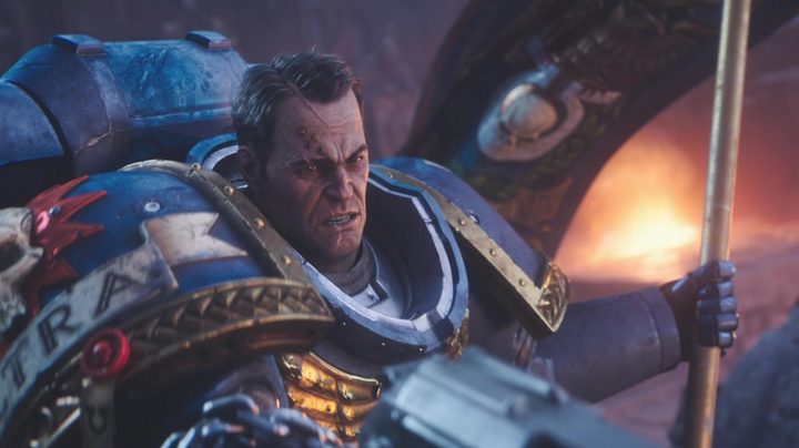 The player’s character, Demetrian Titus, holds a banner while shooting enemies with a pistol in Warhammer 40,000: Space Marine 2.
