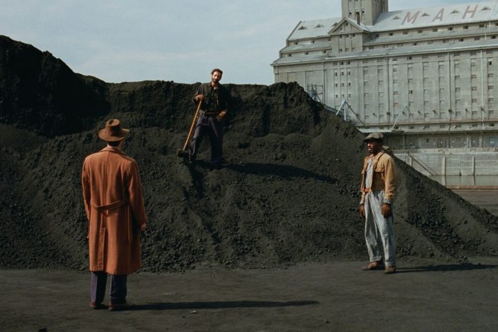 Adrien Brody stands on a pile of dirt in The Brutalist.
