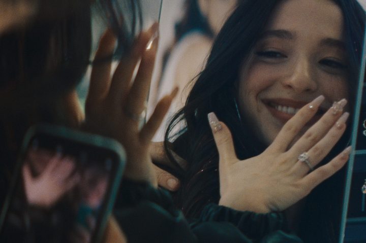 Ani looks at her wedding ring in a mirror in Anora.