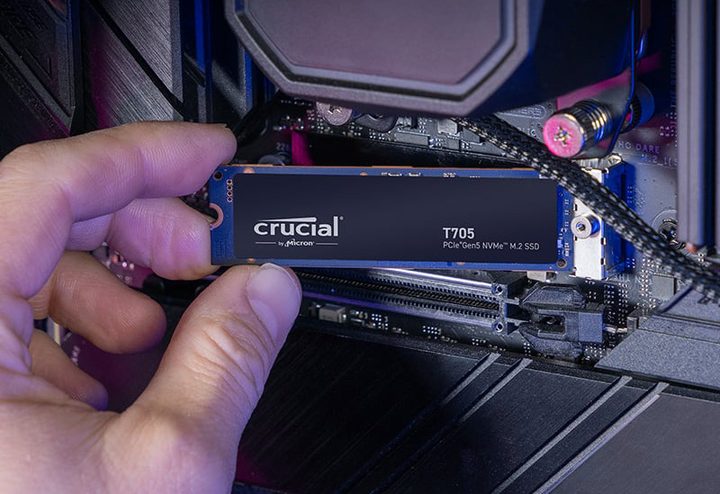 The Crucial T705 PCIe 5.0 SSD held in front of a motherboard.