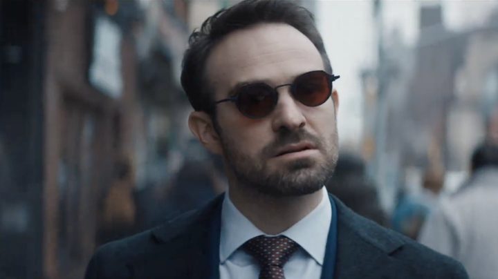 Matt Murdock walks and stares while wearing glasses.