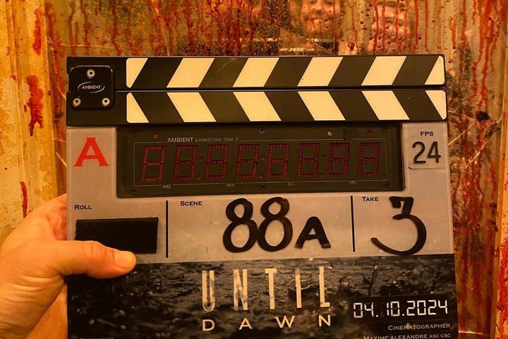 David F. Sandberg holds the Until Dawn film slate up in front of a bloody mirror.