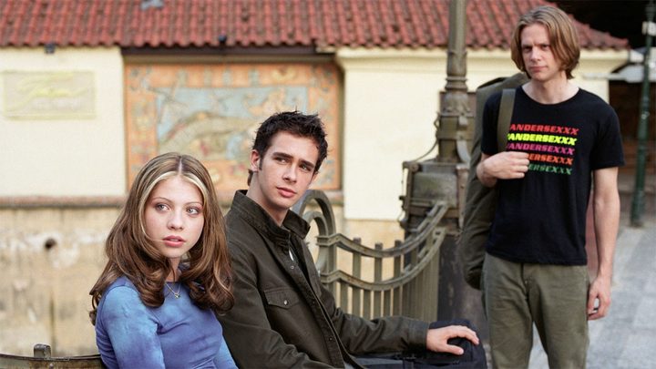 The cast of Eurotrip sits on a bench and stands.