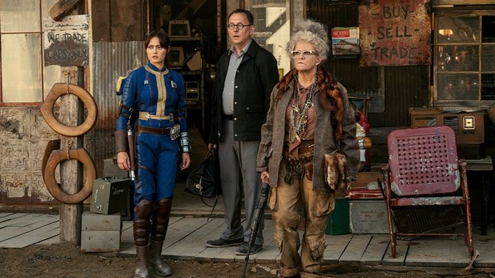Three people stand in Fallout.