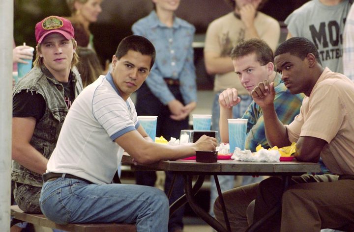 A group of teens sit at a table.