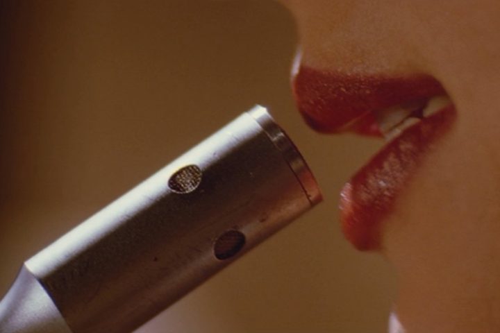 Mia talks into a microphone in Pulp Fiction.
