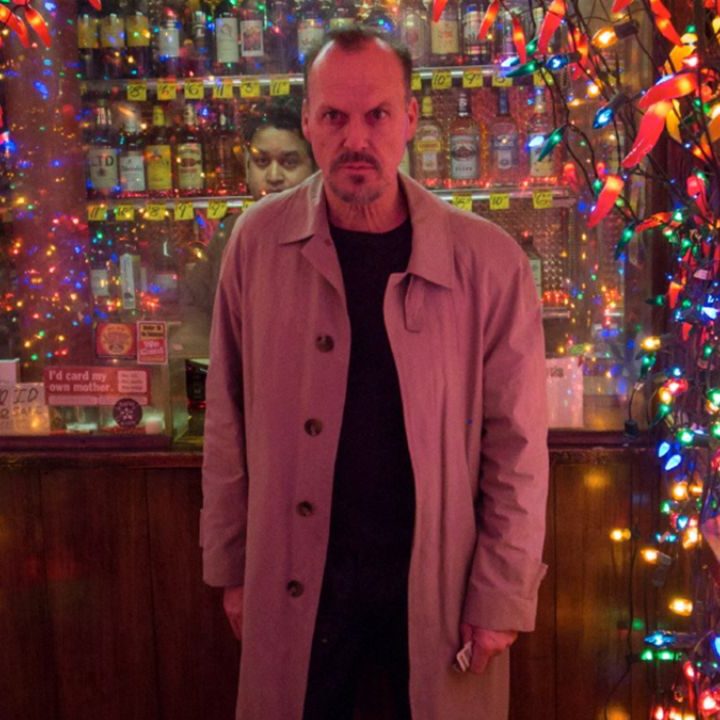 Michael Keaton as Riggan Thomson walking out of a store filled with lights in Birdman.