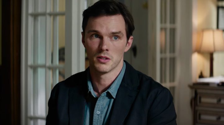Nicholas Hoult sits down and looks worried.