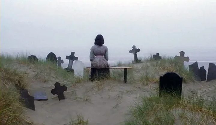 A woman sits in a graveyard in Nosferatu the Vampyre.