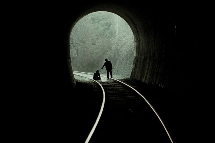 One man points a gun at a kneeling man in Memories of Murder.