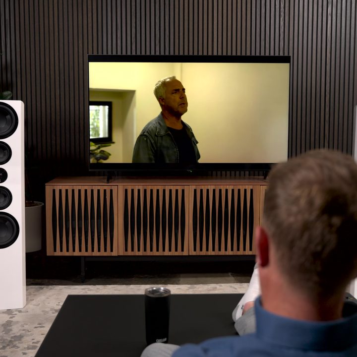 Panasonic W95A TV in a room with a person watching.