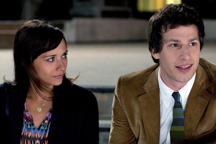 A woman looks at a man as she sits next to him.