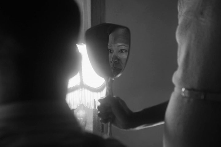 Regina King appears in a mirror's reflection in Watchmen.