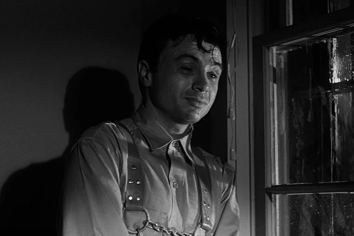 Robert Blake stands near a rain-soaked window in In Cold Blood.