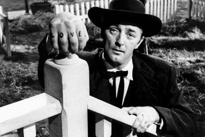 Robert Mitchum holds onto a porch railing in The Night of the Hunter.