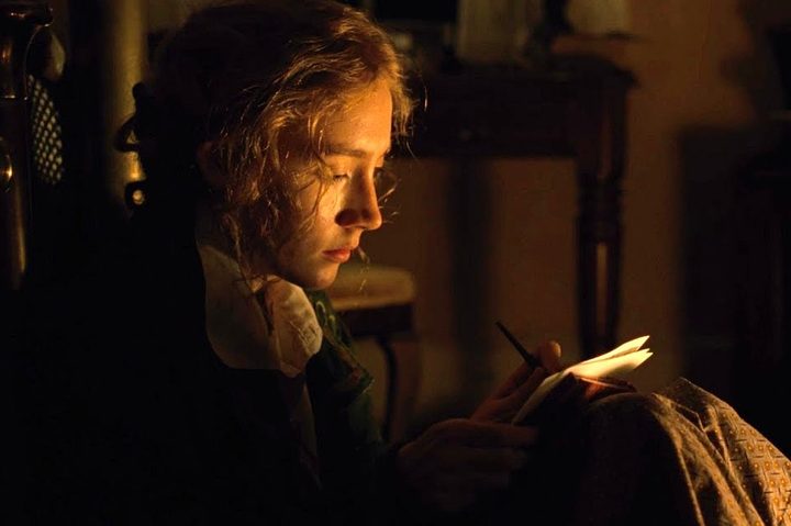 Saoirse Ronan writes in a notebook in Little Women.