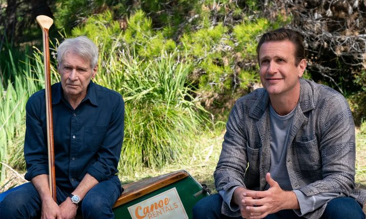 Harrison Ford and Jason Segel sitting side by side outside in a scene from Shrinking.