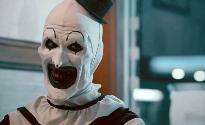 An evil clown smiles sadistically.