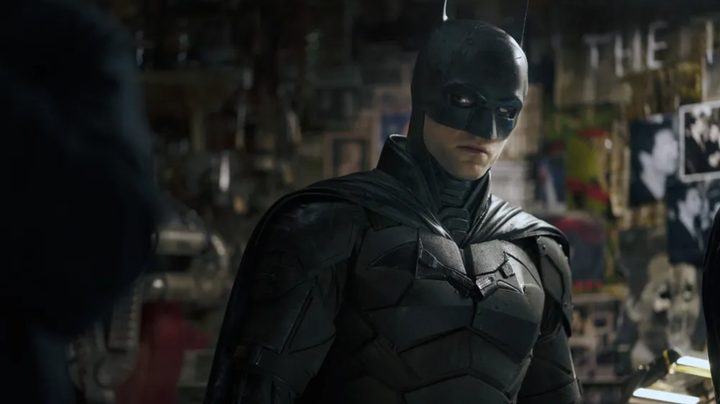 Robert Pattinson as the Dark Knight in The Batman, investigating the Riddler's apartment.