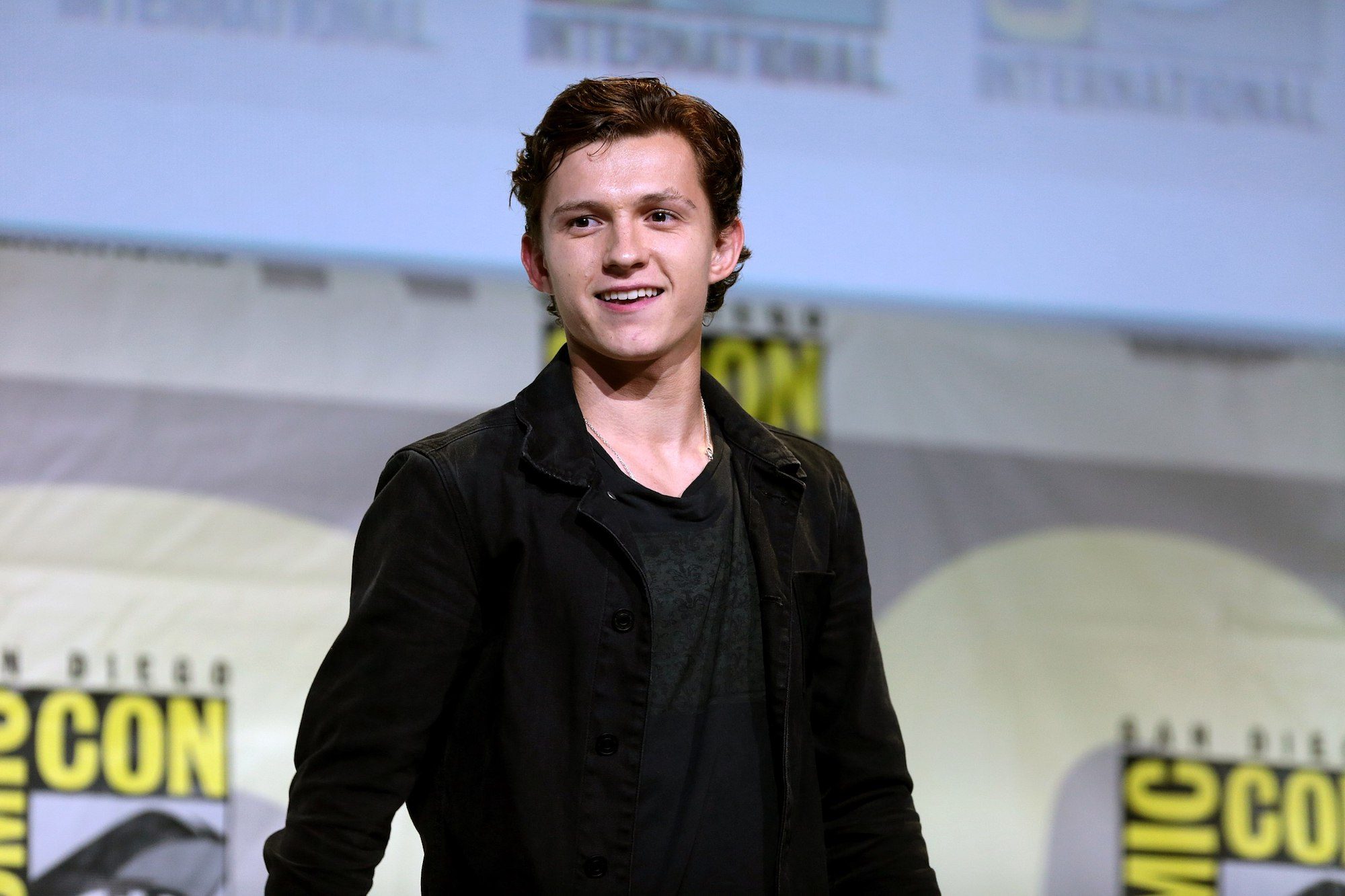 Tom Holland smiles and poses for a picture at Comic-con.