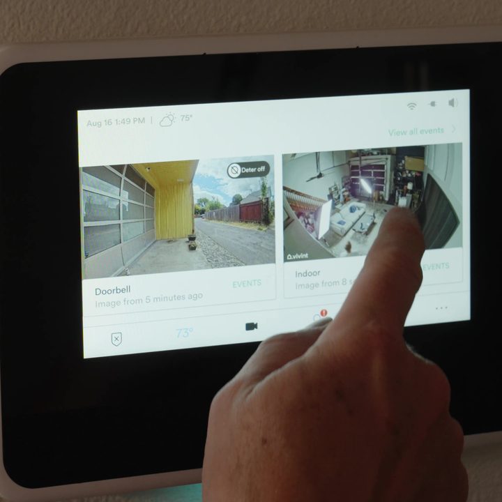 The Vivint Smart Hub mounted on a wall with the camera views on the screen.