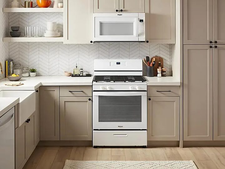 The Whirlpool 5.1 cu. ft. freestanding gas range installed beneath a microwave in a kitchen.