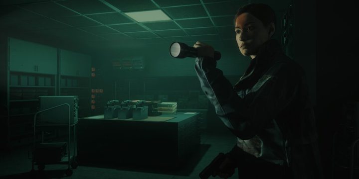 Agent Estevez holding a flashlight in an office room. 