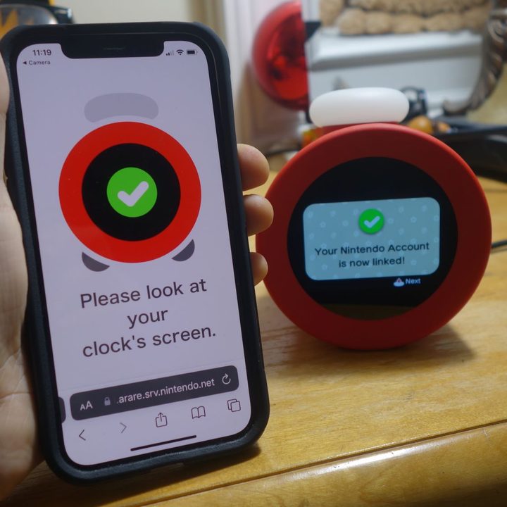 A phone screen appears next to the Alarmo.