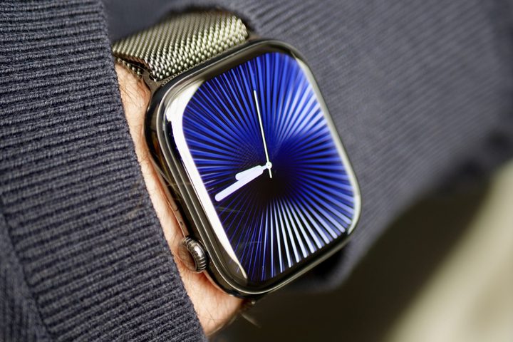 A person wearing the Apple Watch Series 10 in titanium with the Reflections watch face.