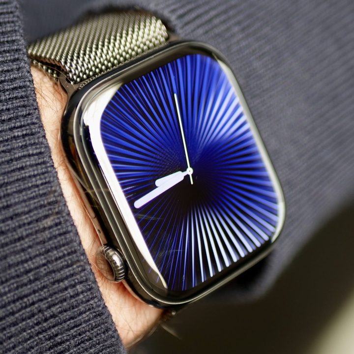 A person wearing the Apple Watch Series 10 in titanium with the Reflections watch face.