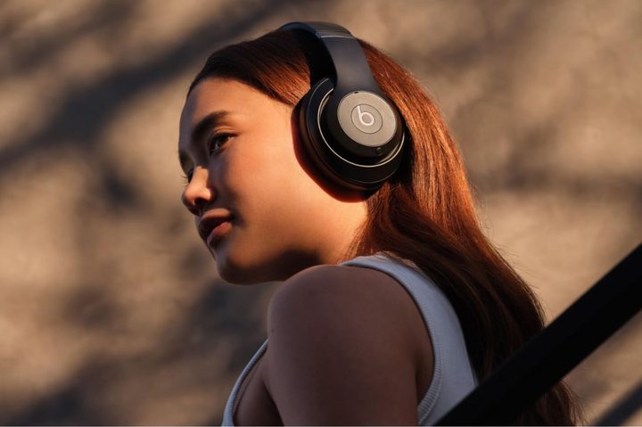 A woman wears Beats Studio Pro wireless headphones.