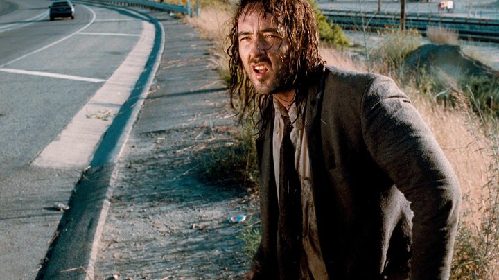 A dirty man stands near a highway in Being John Malkovich.