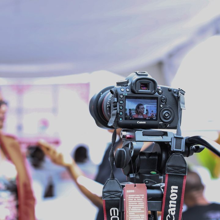 A woman and a camera outdoors.