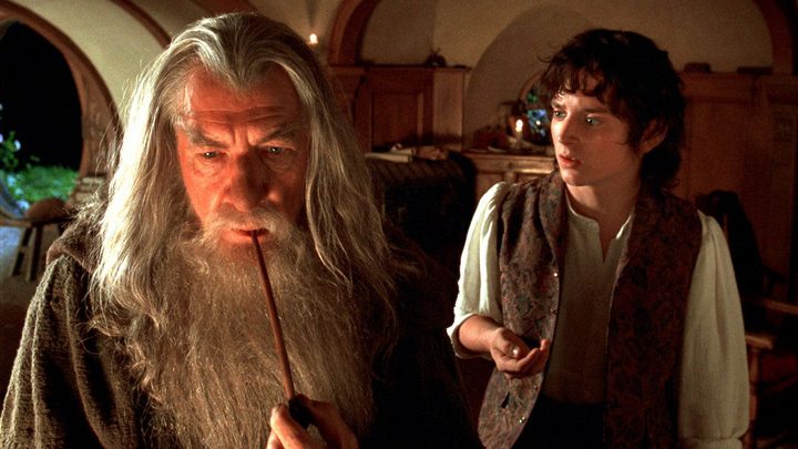 Gandalf in the foreground with Frodo behind him holding the ring in The Lord of the Rings: The Fellowship of the Ring.