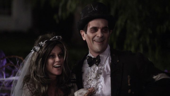 Claire and Phil dressed up as a dead bride and groom for Halloween and smiling on Modern Family.