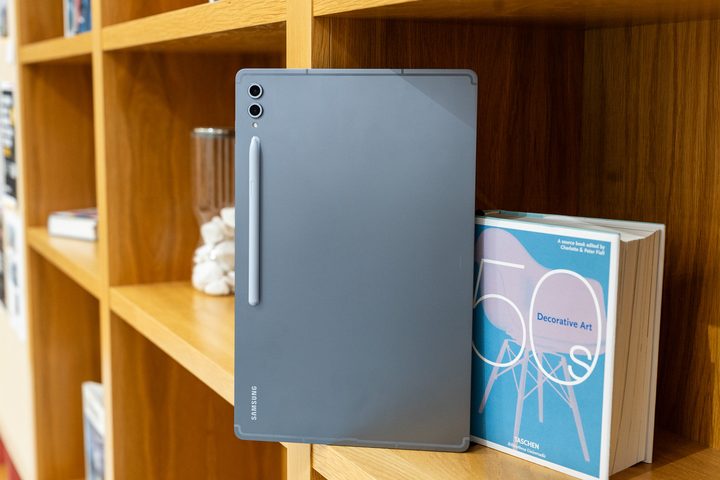 Samsung Galaxy Tab S10 Ultra on a bookshelf.