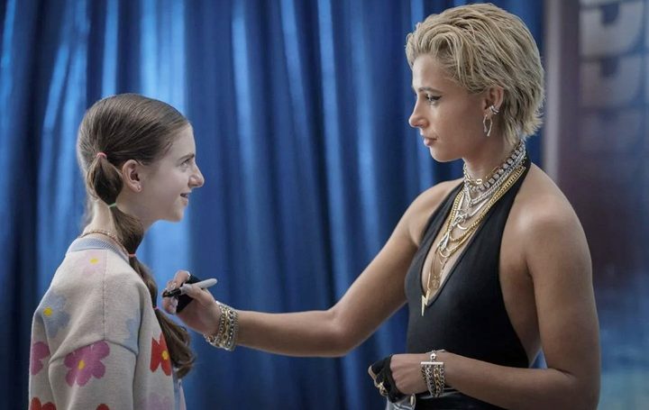A singer signs a fan's chest in Smile 2.